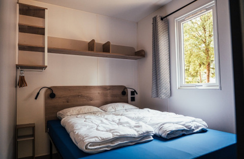 Modernes Schlafzimmer mit Doppelbett und Fenster in der Loggia Wood, Eurocamping Vessem BV, Niederlande.
