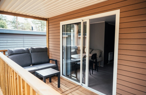 Gemütliche Holzterrasse mit Sitzgruppe an der Loggia Wood im Eurocamping Vessem BV, Niederlande.