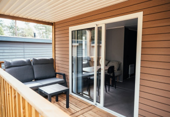 Træterrasse med komfortabel sofa og bord på Loggia Wood, Eurocamping Vessem BV, Holland.