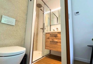 Bagno moderno in Forest Lodge al Holiday Park BreeBronne, Paesi Bassi, con doccia e mobile in legno.