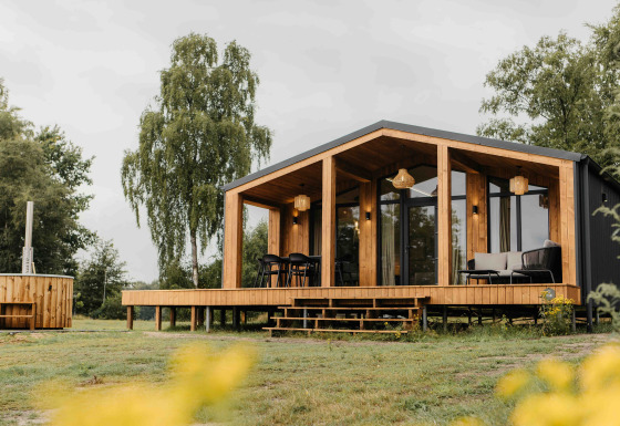 Panorama Lake House Scandi met hottub, moderne houten cabin met terras en grote ramen in de natuur.