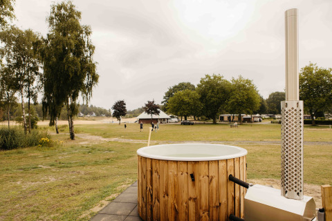 Hottub bij Panorama Lake House Scandi op Wilsumer Berge in Duitsland met uitzicht op grasvelden en bomen.