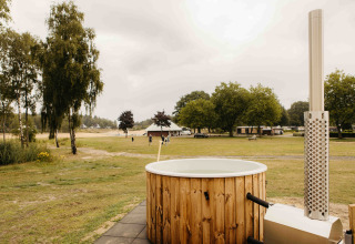 Hottub bij Panorama Lake House Scandi op Wilsumer Berge in Duitsland met uitzicht op grasvelden en bomen.