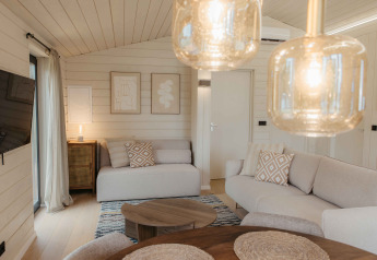 Helles Wohnzimmer im Panorama Lake House Scandi mit Whirlpool, skandinavischem Stil in Wilsumer Berge, Deutschland.