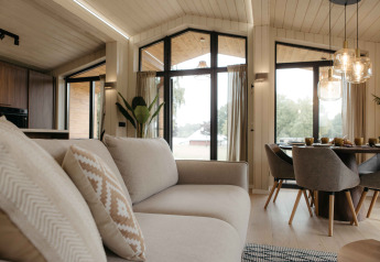 Helles, modernes Wohnzimmer im Panorama Lake House Scandi am Wilsumer Berge mit großen Fenstern.