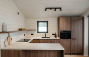 Moderne keuken in Panorama Lake House Scandi met houten kasten, witte wanden en gezellige sfeer.