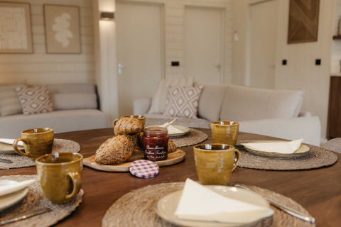 Scandinavische woonkamer in Panorama Lake House met ontbijttafel, brood en koffie in Wilsumer Berge.