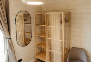 Scandinavische kast, spiegel en fauteuil in Panorama Lake House Scandi bij Wilsumer Berge, Duitsland.