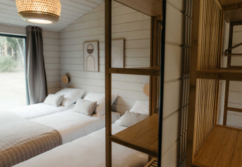 Modernes Schlafzimmer mit zwei Einzelbetten, Holzelementen und Naturblick in Wilsumer Berge, Deutschland.