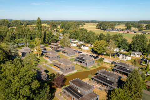Luchtfoto van vakantiepark 't Schuttenbelt in Overijssel, Nederland, omringd door bomen en weilanden.