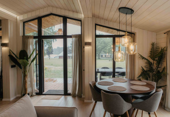 Modernes Interieur der Panorama Lake House Scandi-Hütte in Wilsumer Berge mit Essbereich und großen Fenstern.