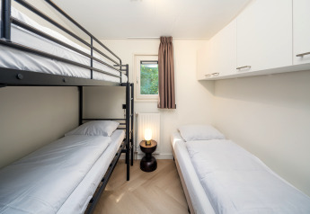 Habitación moderna en Loevestein Comfort, Veluwepark de Bosgraaf, con litera y cama individual.
