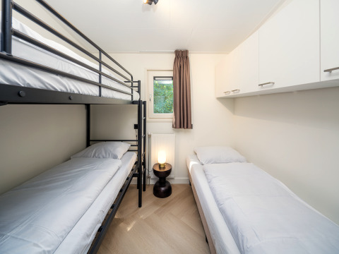 Chambre moderne à Loevestein Comfort, Veluwepark de Bosgraaf, avec un lit superposé et un lit simple.