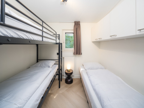 Moderne lodgekamer in Loevestein Comfort, Veluwepark de Bosgraaf, met stapelbed en eenpersoonsbed.