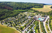 Vista aerea del parco vacanze Camping Nommerlayen in Lussemburgo, circondato da foreste e campi.
