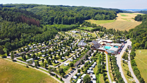 Vista aérea del Camping Nommerlayen en Luxemburgo, rodeado de bosques verdes y campos abiertos.