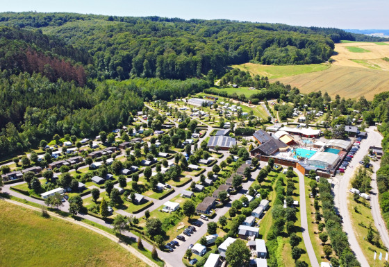 Vista aérea del Camping Nommerlayen en Luxemburgo, rodeado de bosques verdes y campos abiertos.