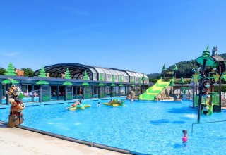 Udendørs pool med børnevenlige vandrutsjebaner og figurer i Camping Nommerlayen, Luxembourg, på en solrig dag.