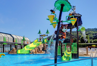 Water park at Camping Nommerlayen, Luxembourg with slides, animal figures, and water features on a sunny day.