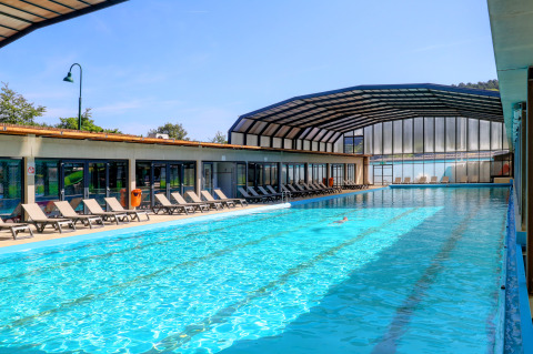 Outdoor and indoor swimming pool with loungers at Camping Nommerlayen holiday park in Luxembourg, Luxembourg.