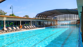 Outdoor and indoor swimming pool with loungers at Camping Nommerlayen holiday park in Luxembourg, Luxembourg.