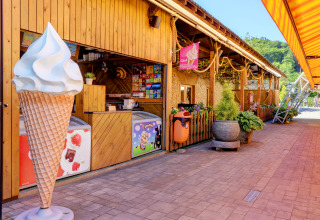 Isbod på Camping Nommerlayen i Luxembourg med stor isvaffelmodel og farverig udendørs dekoration.