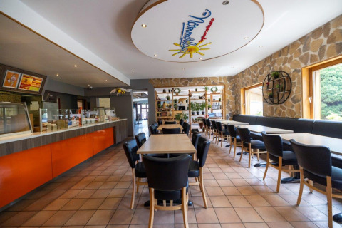 Zona de comedor en Camping Nommerlayen, Luxemburgo, con decoración moderna y ventanas grandes y luminosas.