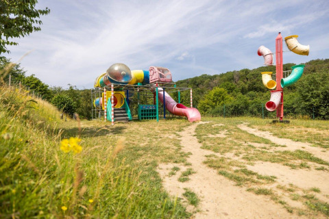 Playground with colorful slides and climbing structures at Camping Nommerlayen holiday park in Luxembourg.
