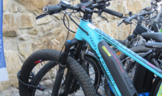 Elektrisk cykel parkeret foran en stenmur i Camping Nommerlayen, en ferielejr i Luxembourg.