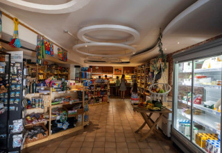 Shop with shelves, fridge, and shoppers at Camping Nommerlayen, a holiday park in Luxembourg, Luxembourg.