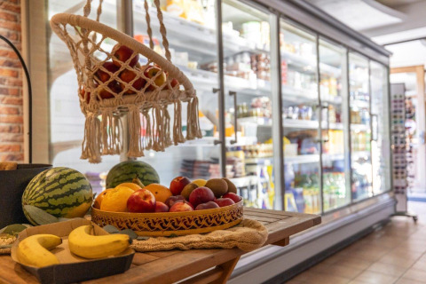 Fresh fruits including bananas, apples, and watermelon at a store in Camping Nommerlayen, Luxembourg.