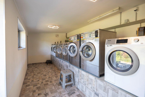 Laundry room with several washing machines at Camping Nommerlayen holiday park in Luxembourg, Luxembourg.