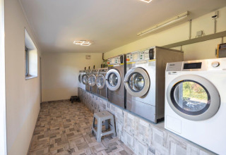 Laundry room with several washing machines at Camping Nommerlayen holiday park in Luxembourg, Luxembourg.