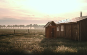 Alba su una tenda a Feather Down De Appelsche in Frisia, Paesi Bassi, circondata da campi erbosi.