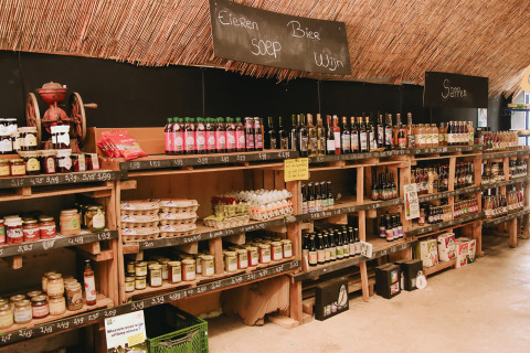 Estanterías con productos locales y bebidas en Feather Down De Appelsche, Friesland, Países Bajos, casa rural.
