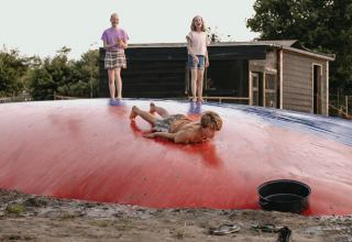 Niños juegan en un gran colchón inflable en Feather Down De Appelsche, un parque vacacional en Friesland, Países Bajos.