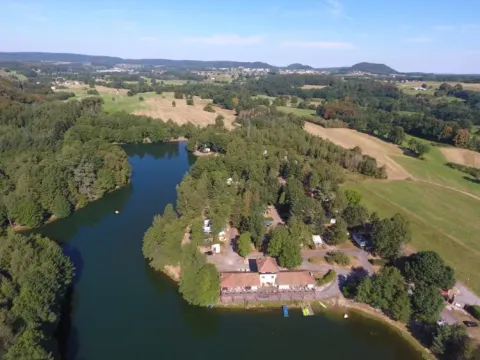 Vue aérienne du Domaine des Messires, parc de vacances entouré de lac, bois et champs en Grand Est, France.