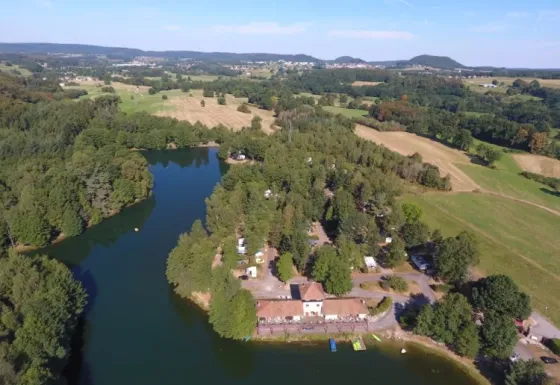 Vista aérea del parque de vacaciones Domaine des Messires con lago, bosques y campos en Grand Est, Francia.