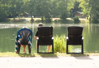 Deux personnes se détendent près du lac au Domaine des Messires, un parc de vacances du Grand Est, France.