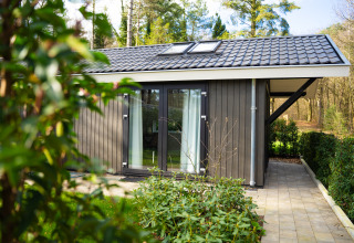 Vista exterior de Bos Cottage en De Thijmse Berg, Países Bajos, rodeada de vegetación y bosque.