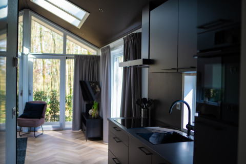 Moderne lodge Bos Cottage ved De Thijmse Berg i Holland med stilfuldt interiør og store vinduer.