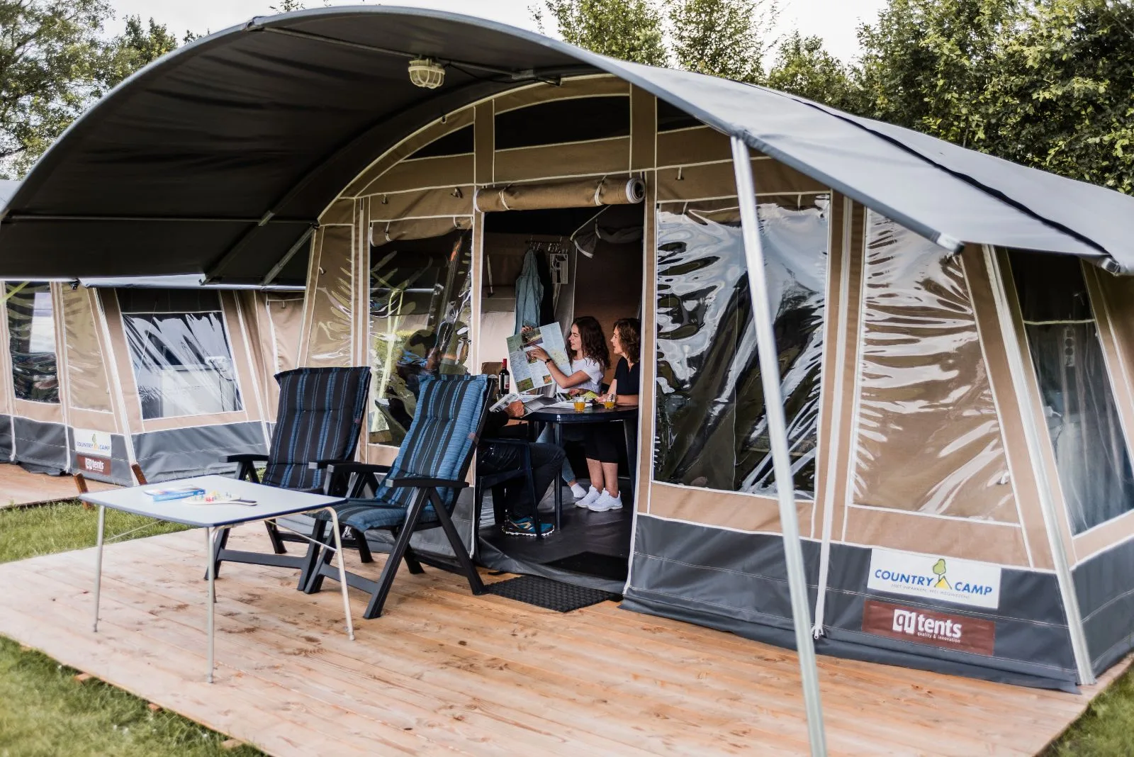 Safaritent Lodge de Luxe bij Domaine des Messires in Frankrijk, gasten genieten samen op het terras.