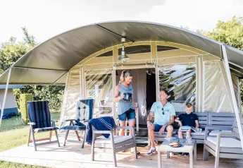 Famiglia si rilassa davanti a una tenda safari Lodge de Luxe al Domaine des Messires, in Francia.