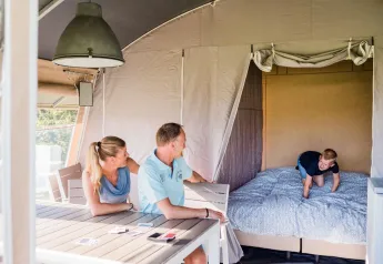 Family enjoying time together in a Lodge de Luxe safari tent at Domaine des Messires in France.
