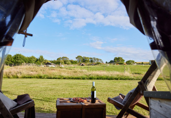 Vista da una tenda safari con vino e pizza su una fattoria a East Shilvinghampton, Regno Unito.