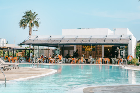 Outdoor dining area by the pool at Camping Costa del Sol Glamping Village holiday park in Andalusia, Spain.