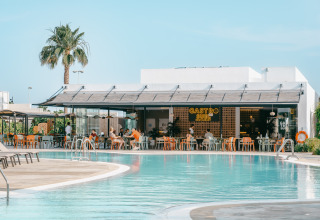 Outdoor dining area by the pool at Camping Costa del Sol Glamping Village holiday park in Andalusia, Spain.