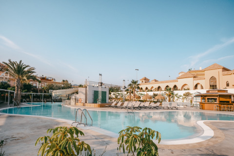 Outdoor swimming pool with sun loungers at Camping Costa del Sol Glamping Village in Andalusia, Spain on a clear day.