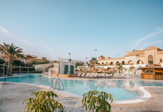 Piscina all'aperto e lettini al Camping Costa del Sol Glamping Village in Andalusia, Spagna, in una giornata soleggiata.