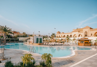 Area piscina al Camping Costa del Sol Glamping Village con lettini e bar in Andalusia, Spagna.